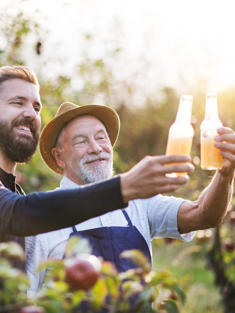 People toasting with cider bottles